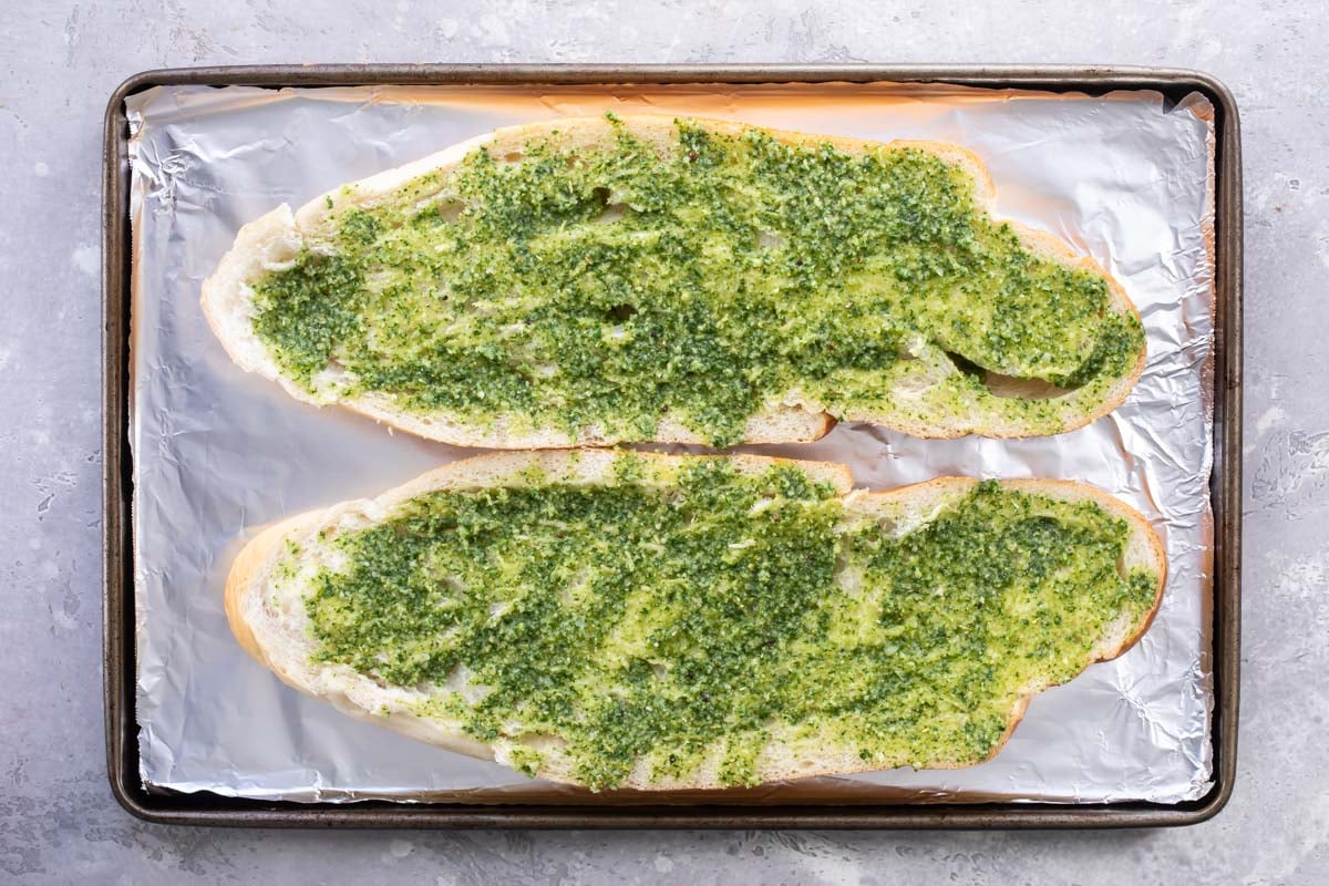 Pesto spread on halves of French bread.
