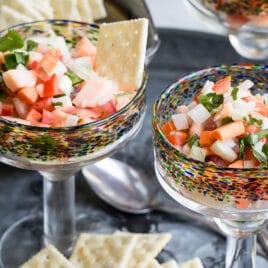 An angled shot of salmon ceviche in stemmed glasses.