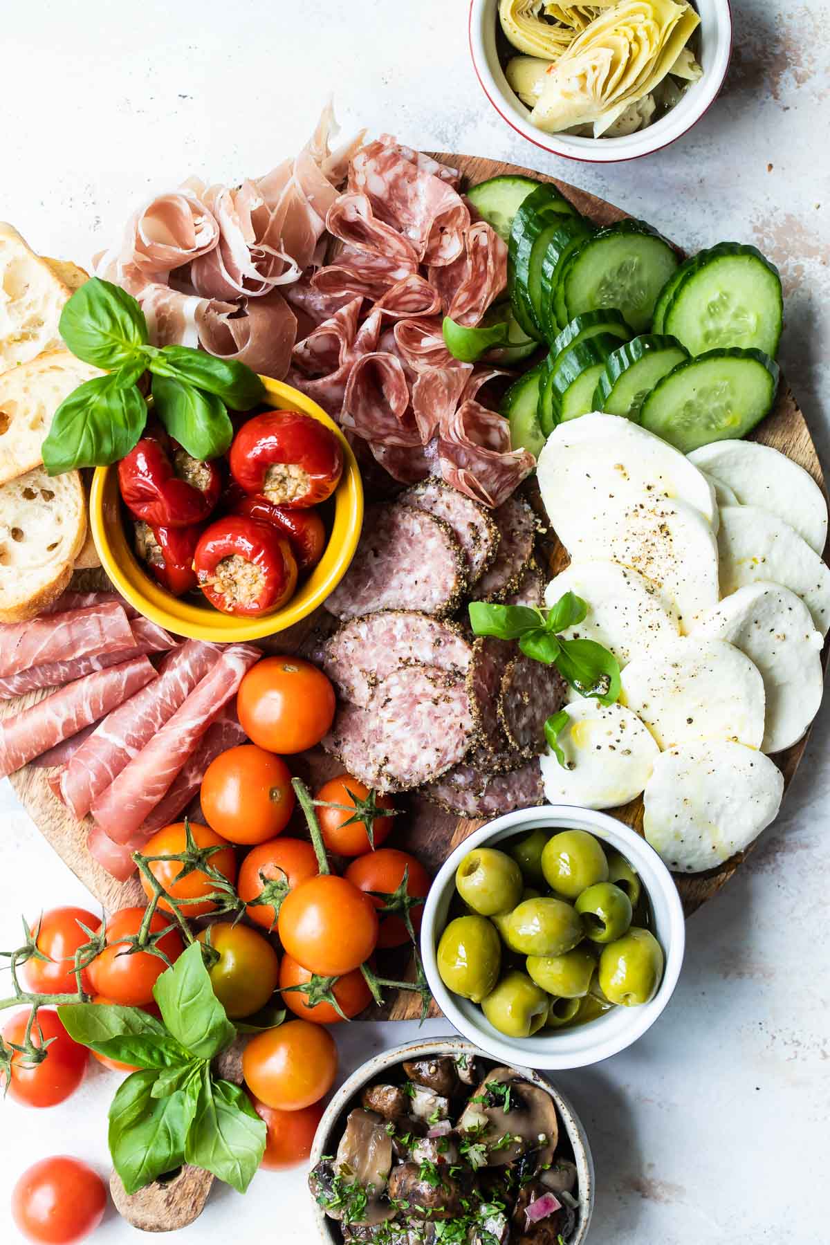 An antipasto platter on a wooden tray.