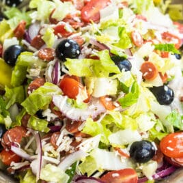 Antipasto salad mixed in a wooden bowl.