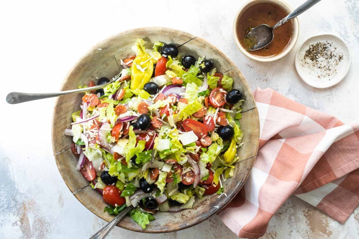 Antipasto salad mixed in a wooden bowl.