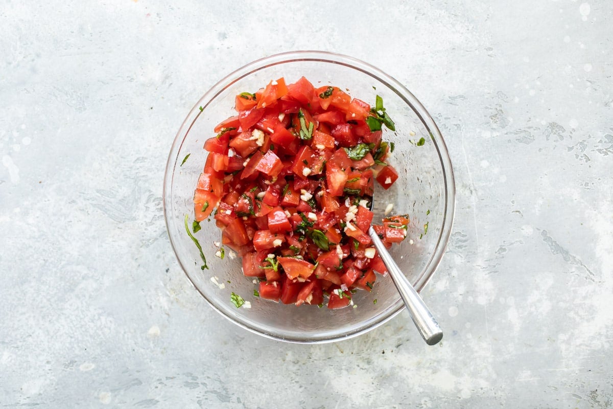 A tomato and spice mixture in a clear bowl.