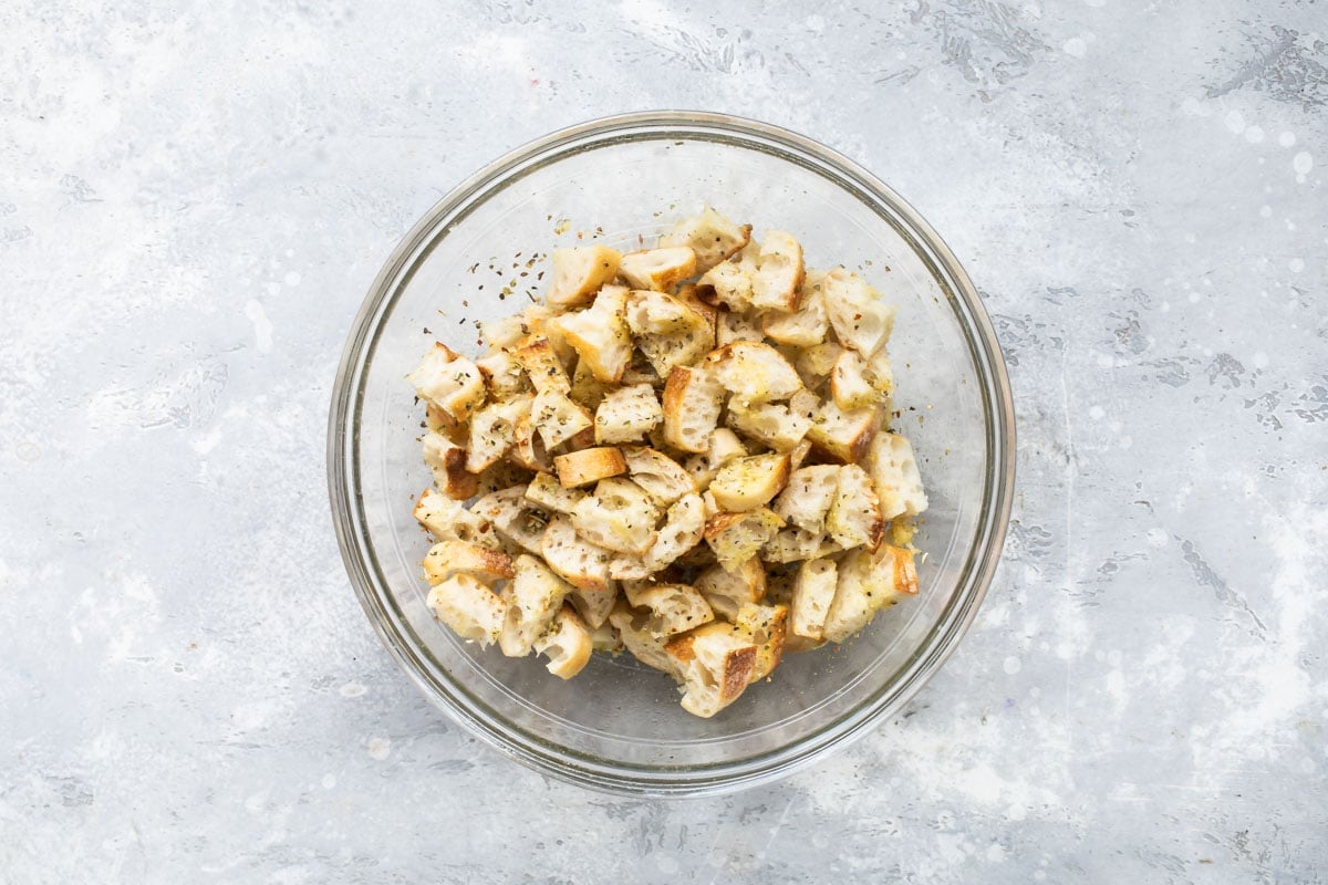 A bowl of bread pieces coated in oil and spices.