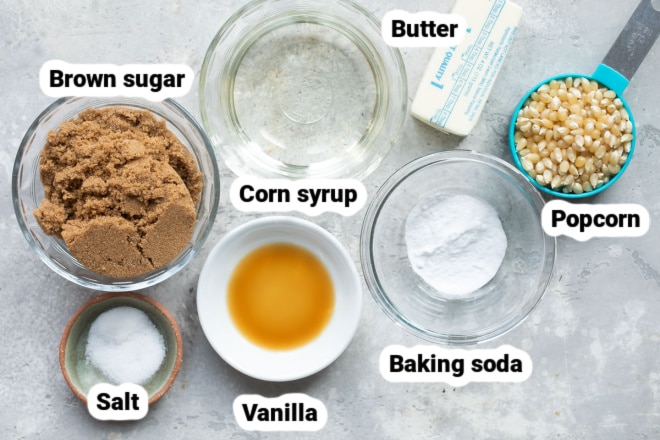 Labeled ingredients for caramel corn in various bowls.