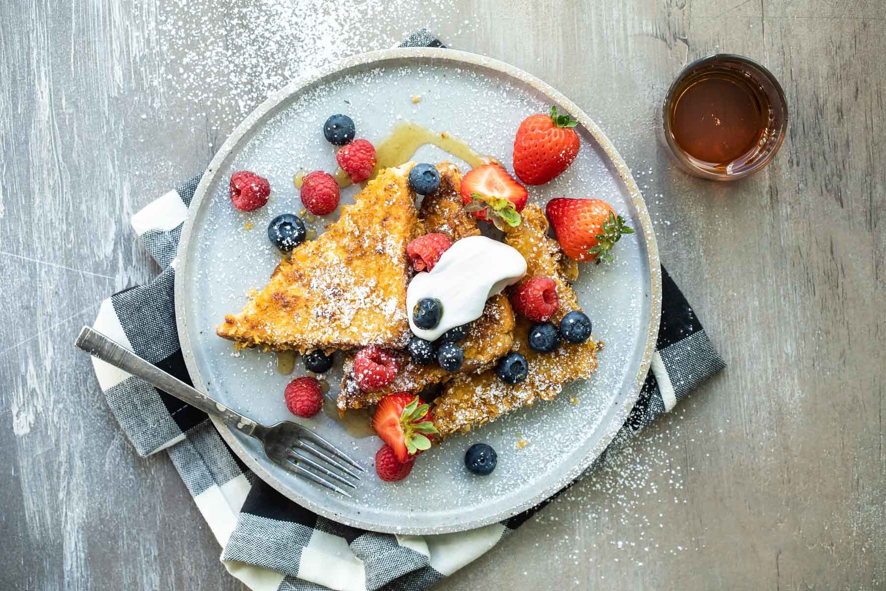 A plate of cornflake crusted french toast with fruit.