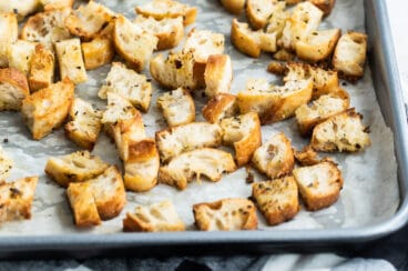 Croutons on a parchment lined baking sheet.