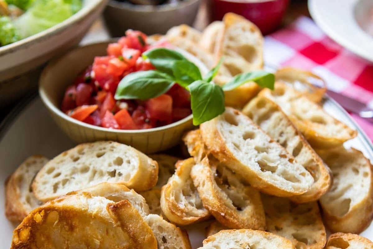 Toasted baguettes on a white platter.