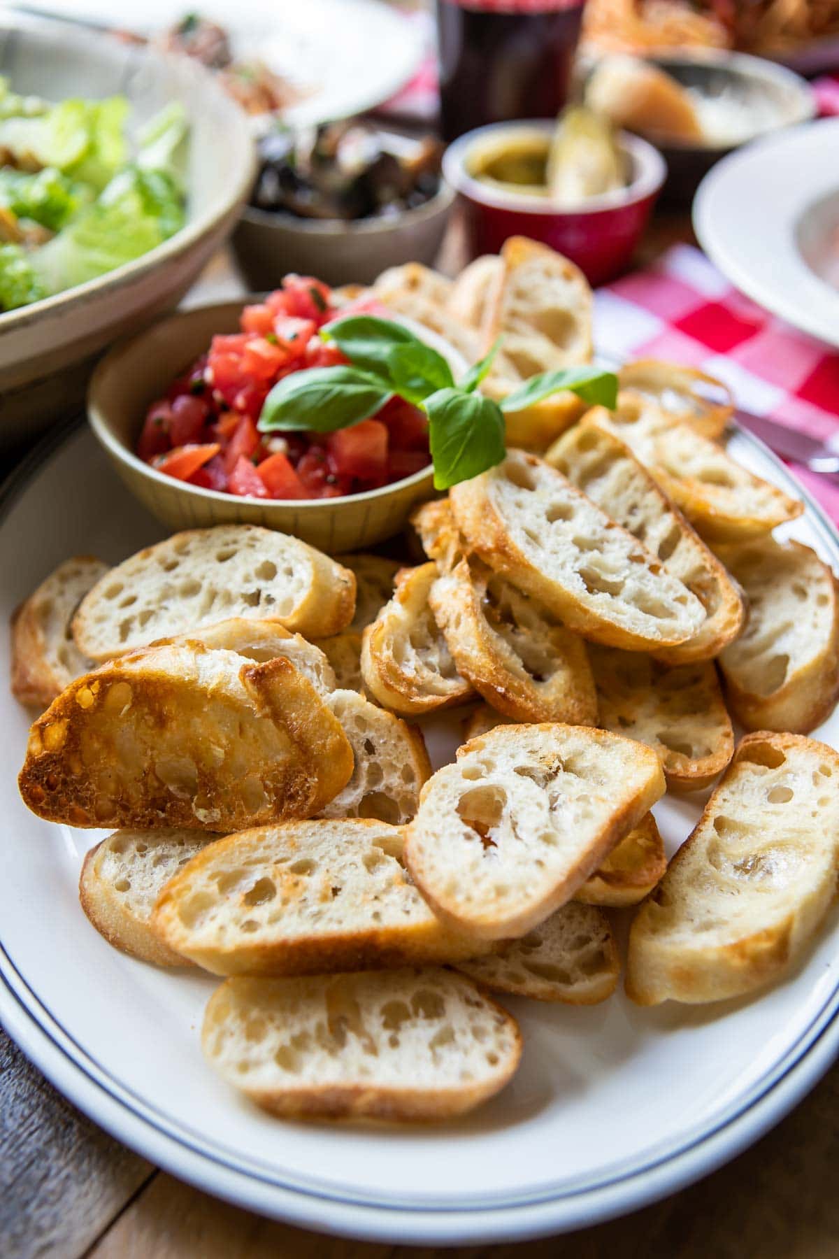 Toasted baguettes on a white platter.