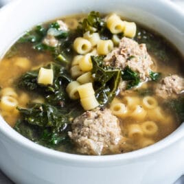 Italian wedding soup in a white bowl.