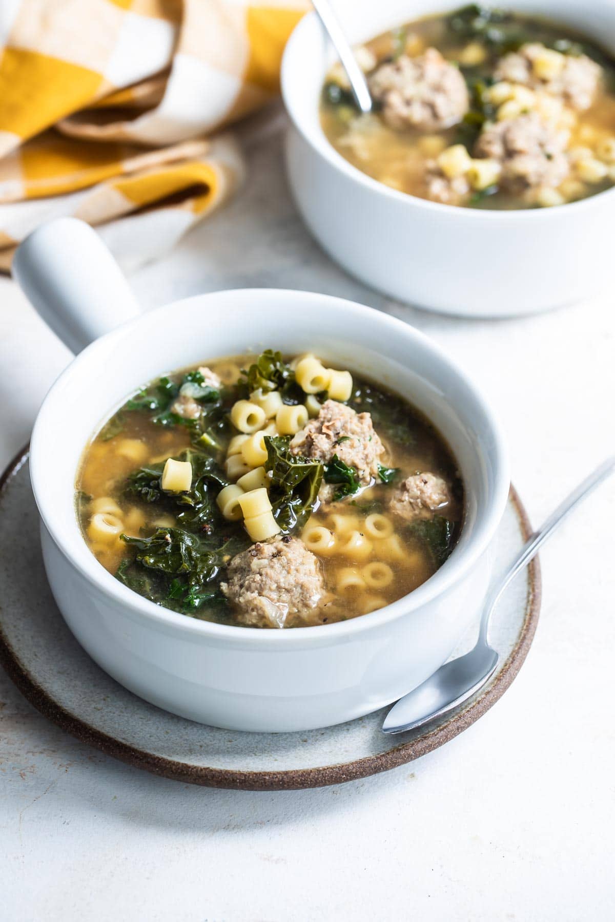 Italian wedding soup in a white bowl.