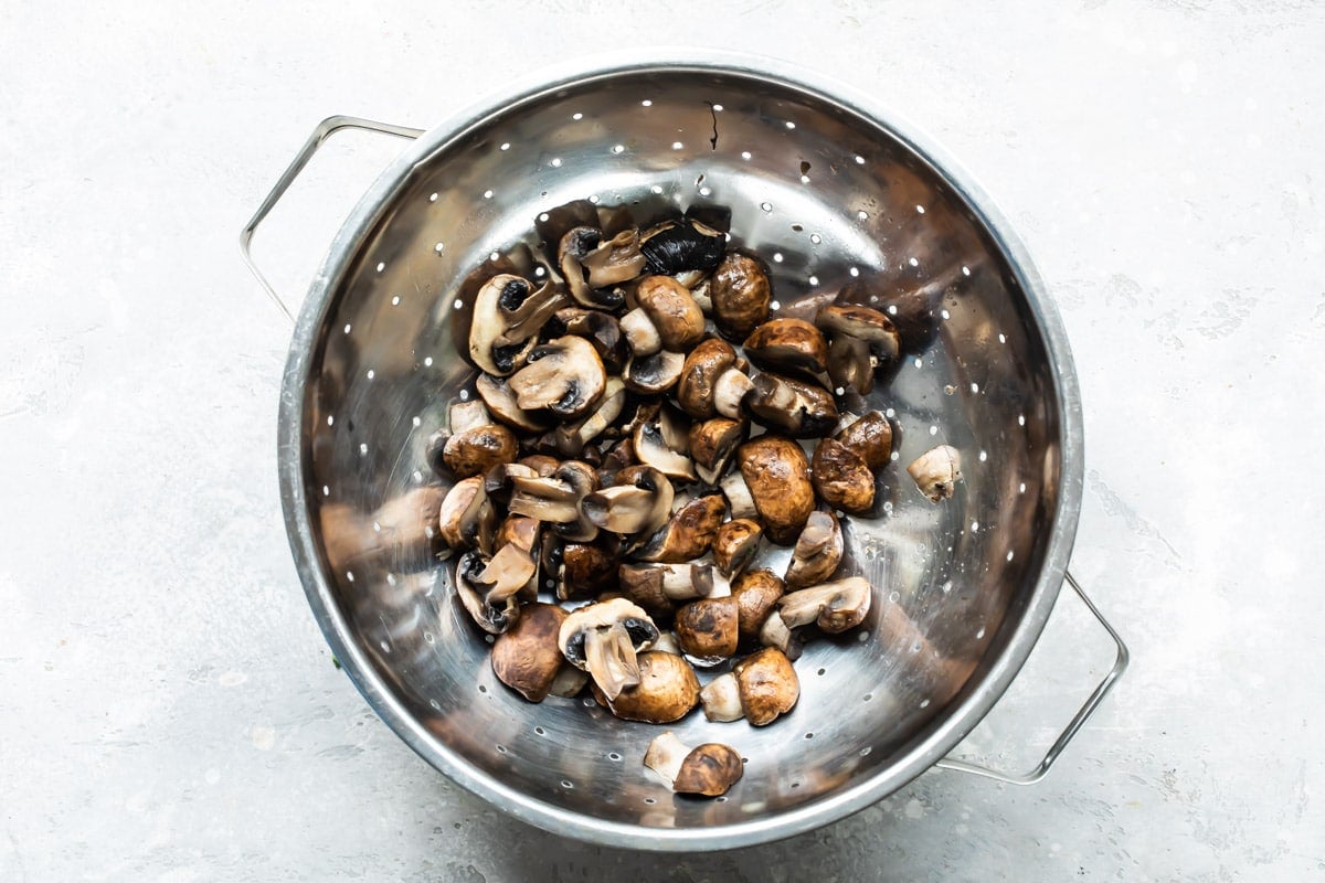 Mushrooms in a silver colander.