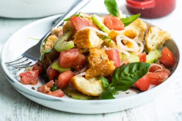 Two plates with Panzanella salad.