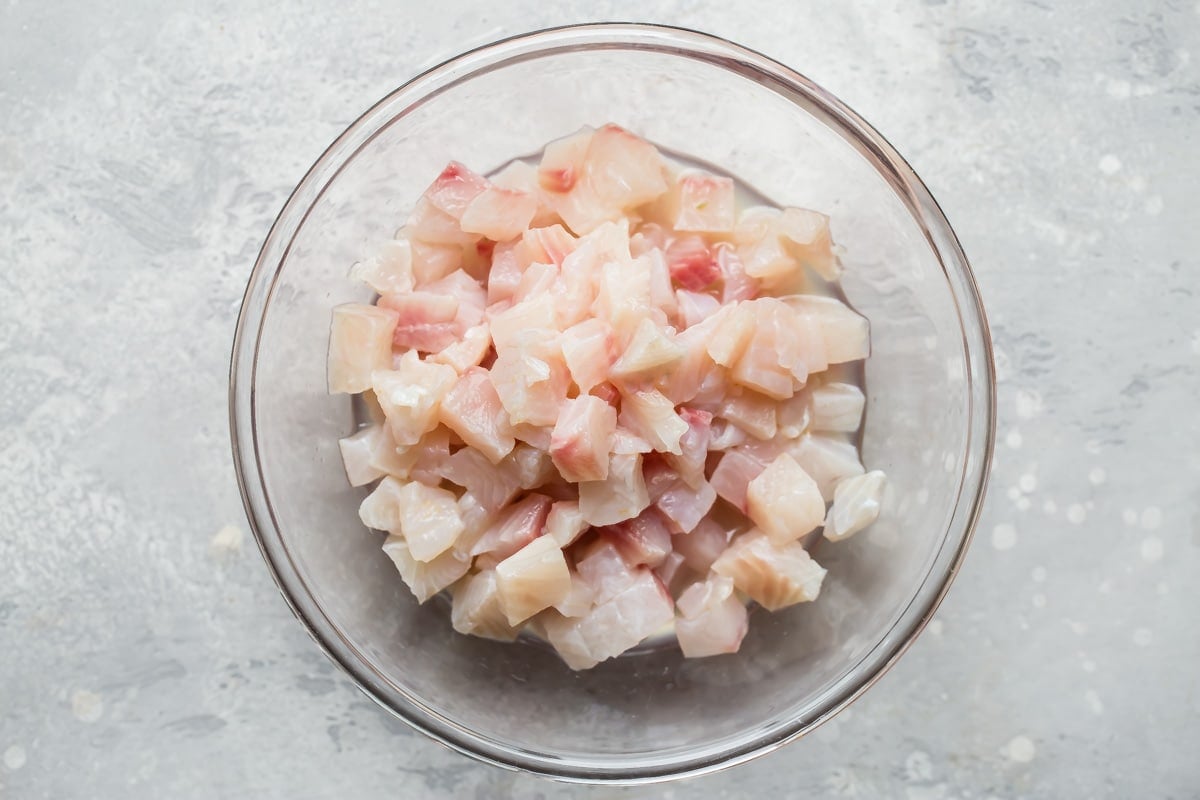 Cubed tilapia in a clear bowl.