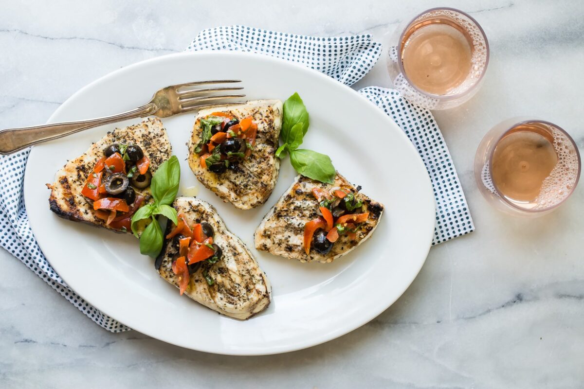 A platter with grilled swordfish on it.