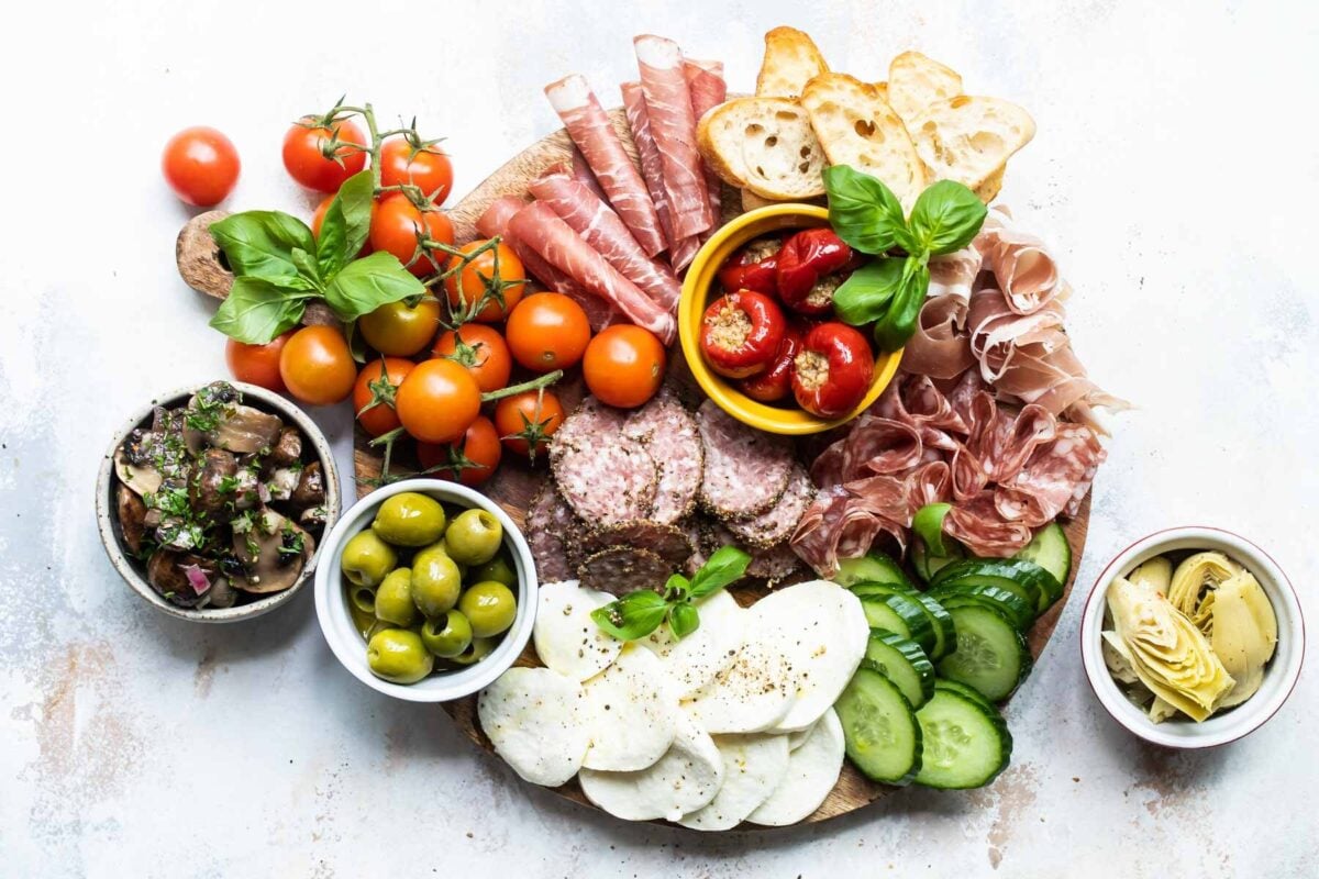 An antipasto platter on a wooden tray.