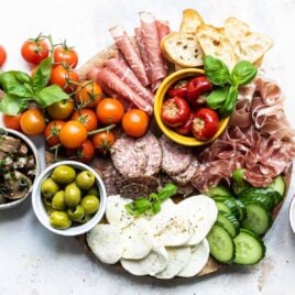 An antipasto platter on a wooden tray.