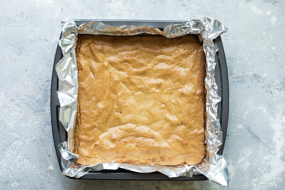 Blondies in a baking pan lined with tin foil.