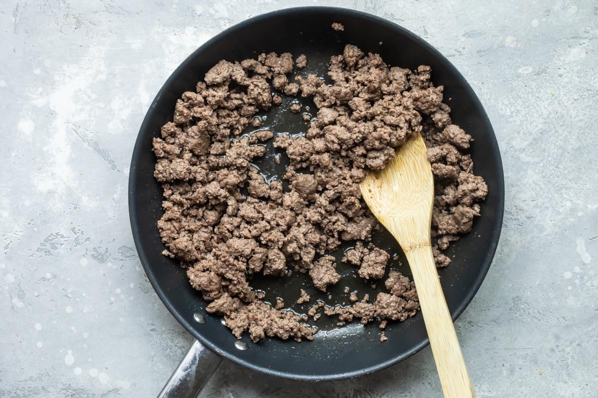 A skillet with cooked hamburger.