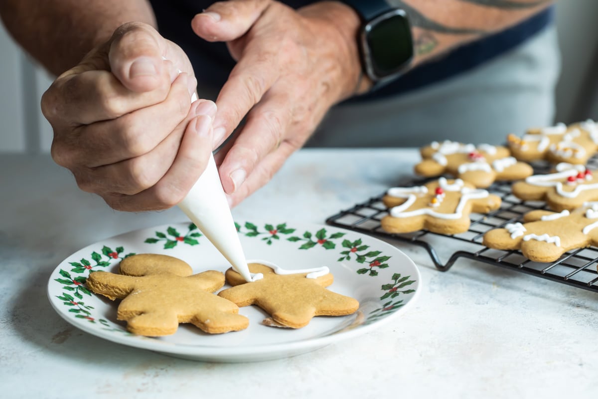Decorating gingerbread cookies on a plate.