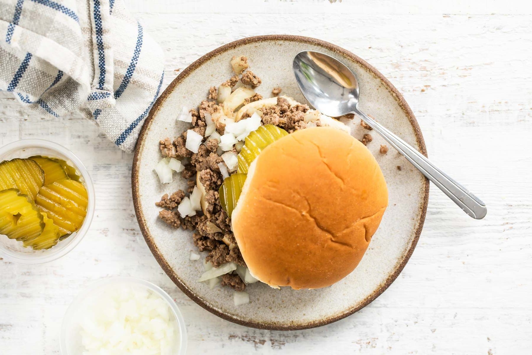 A loose meat sandwich on a plate.