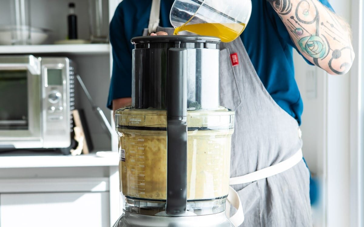 Oil being poured into a food processor.