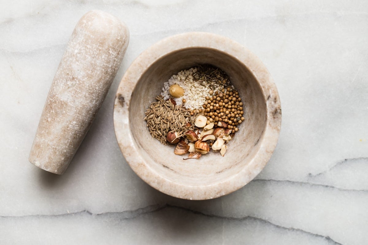 Dukkah ingredients in a mortar to be crushed.