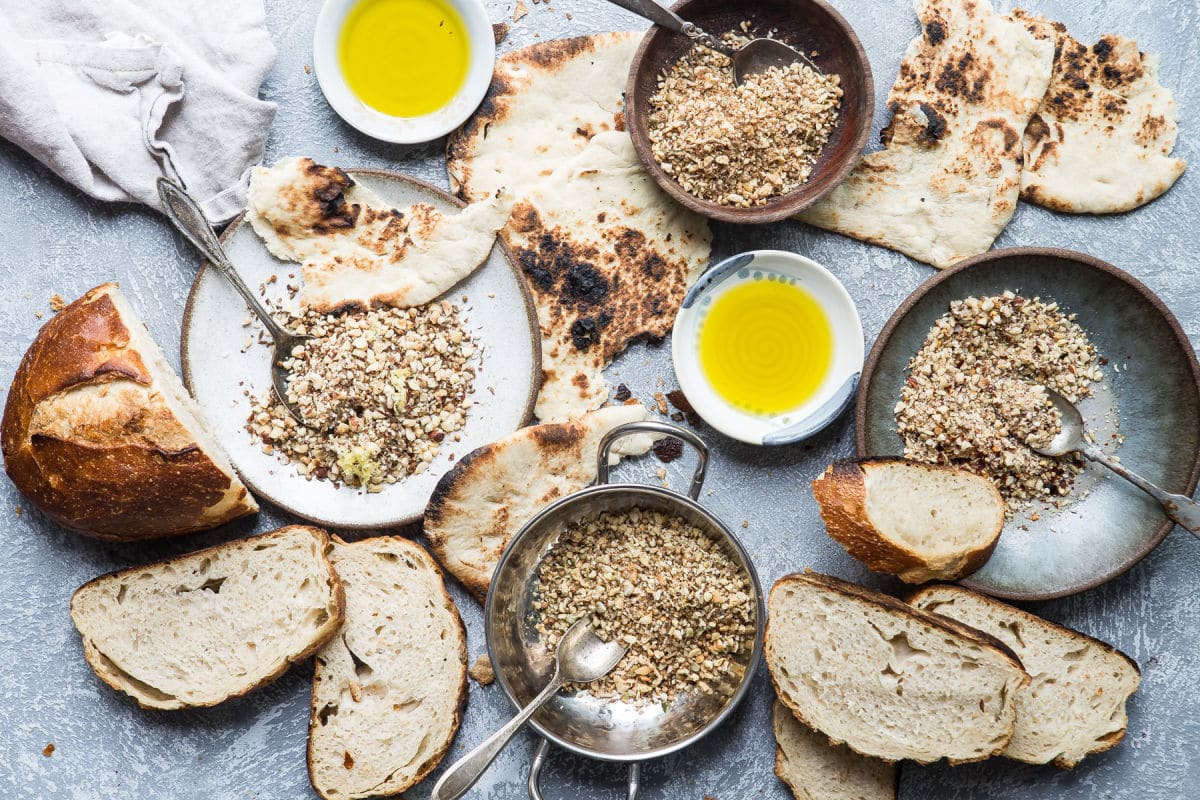 Dukkah on a blue plate with pita bread.