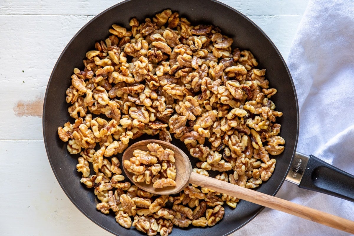 Toasted walnuts in a skillet.