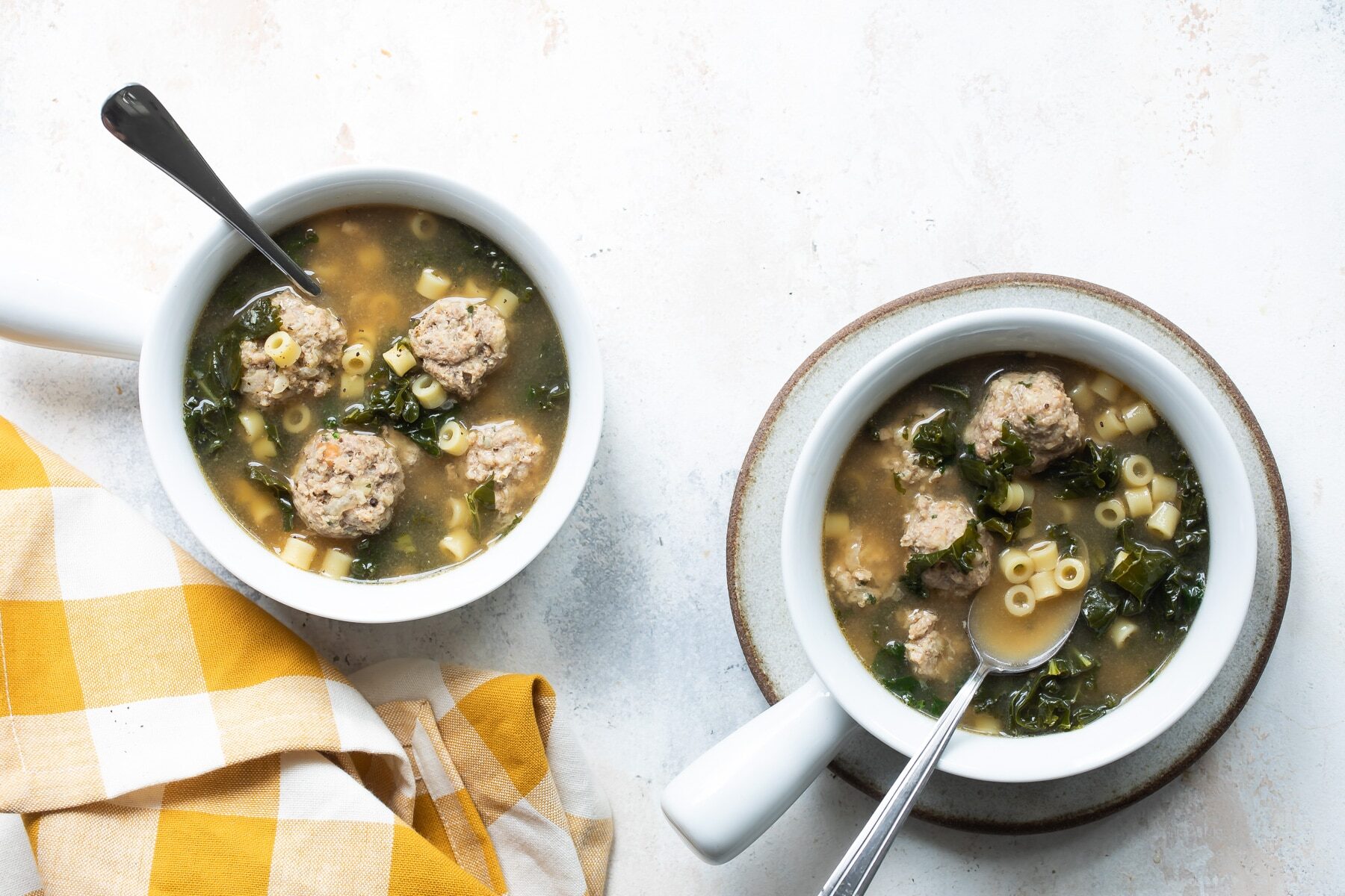 Italian wedding soup in two white bowls.