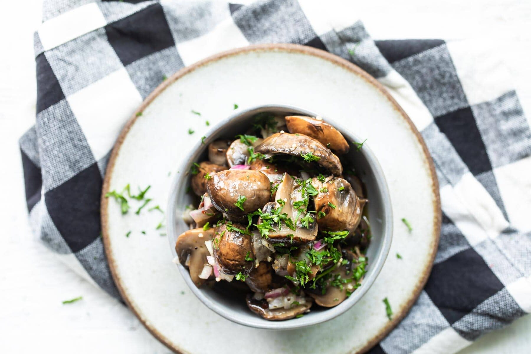 Marinated mushrooms in a gray bowl.
