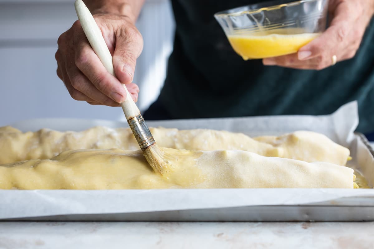 Brushing apple strudels with egg wash.
