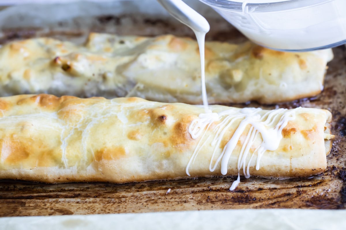 Two apple strudels on a baking sheet.