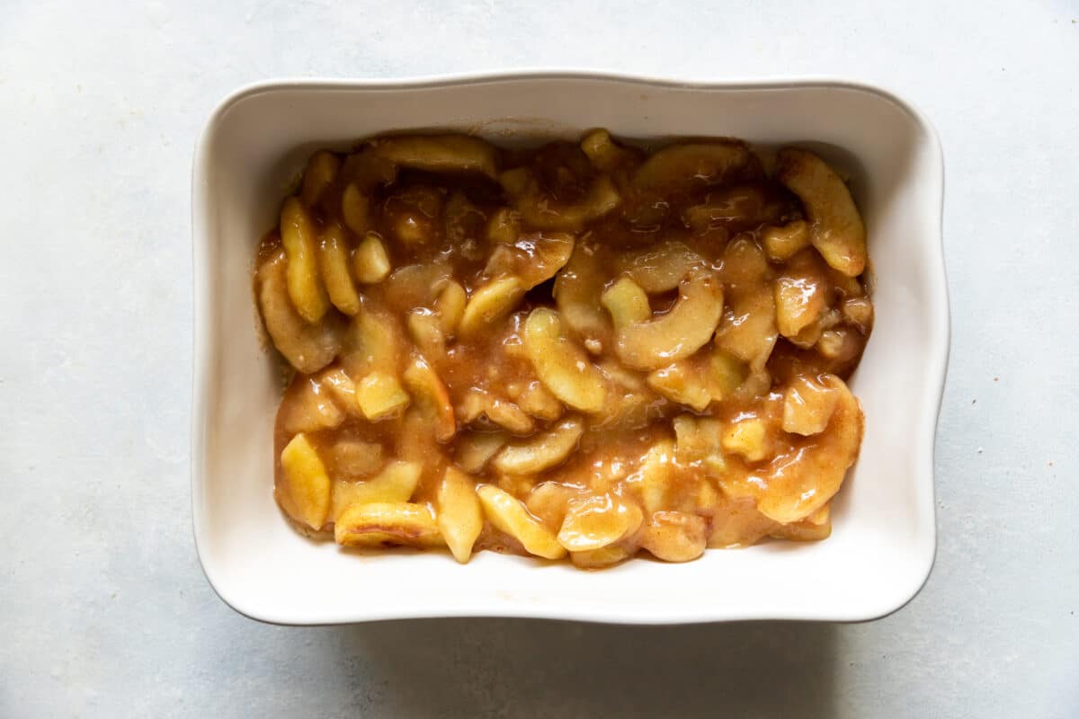 A baking dish filled with apple pie filling.