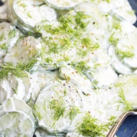 Creamy cucumber salad on a blue plate.