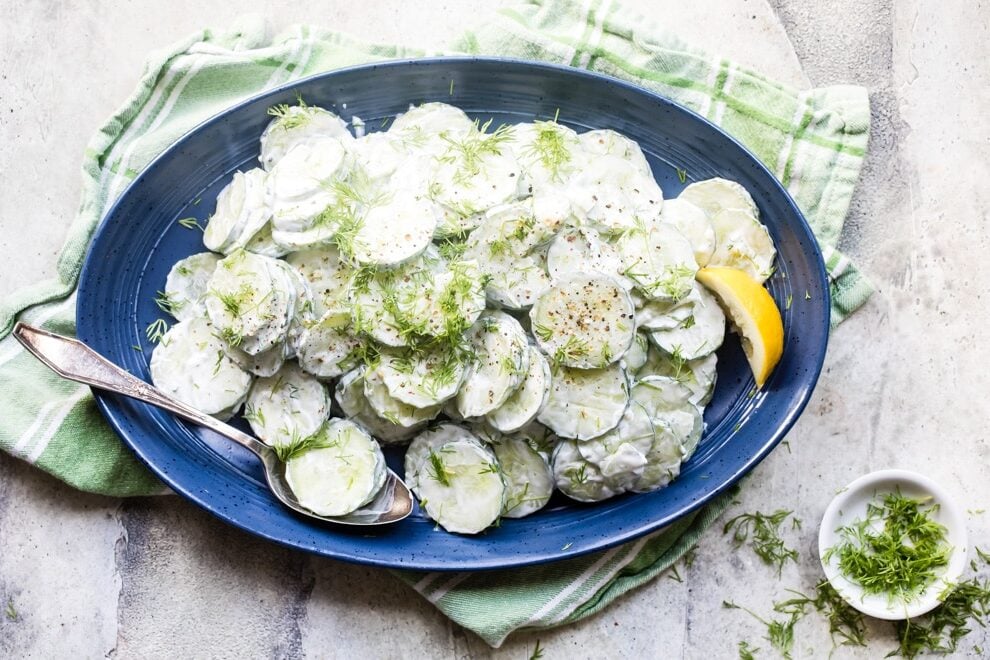 Creamy cucumber salad on a blue plate.