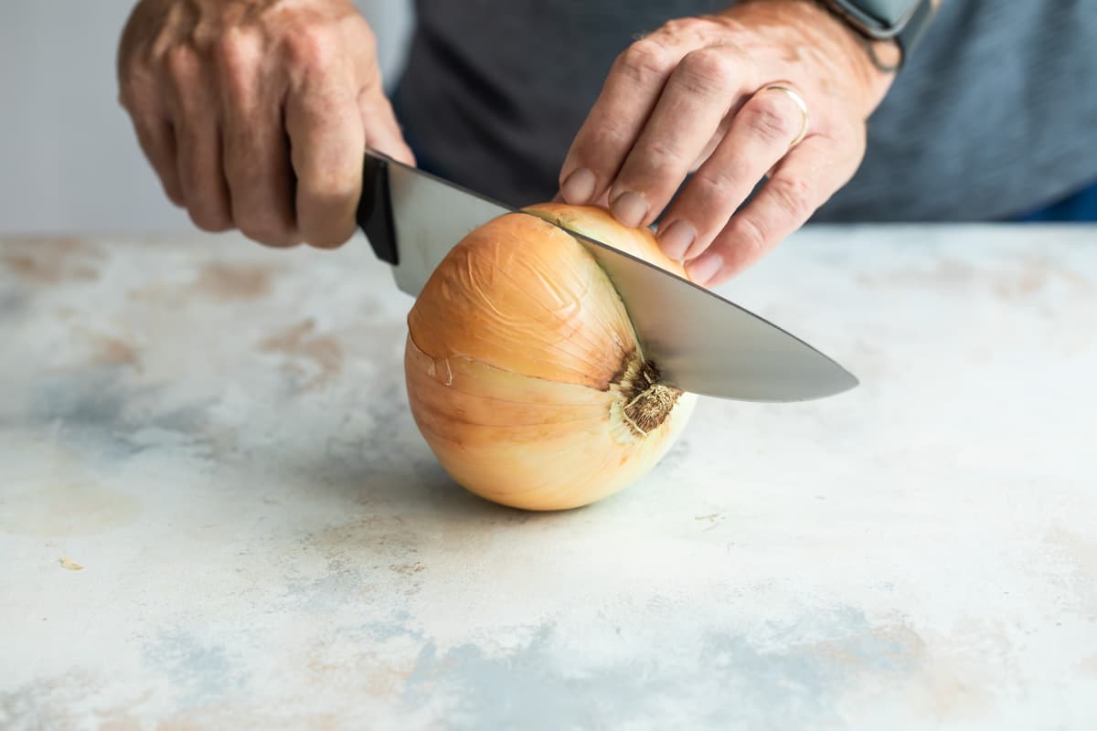 Cutting an onion in half.