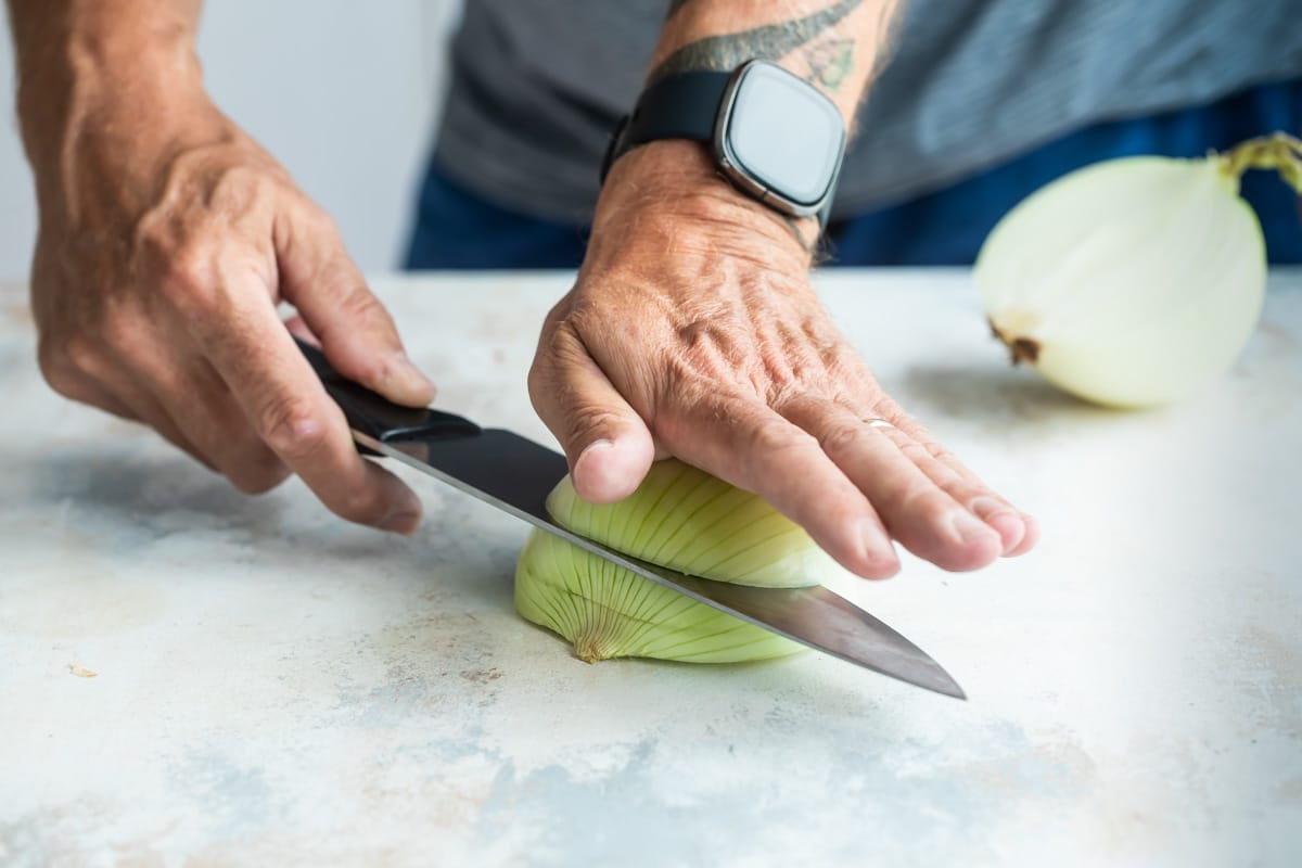 Making slices lengthwise through an onion for dicing.