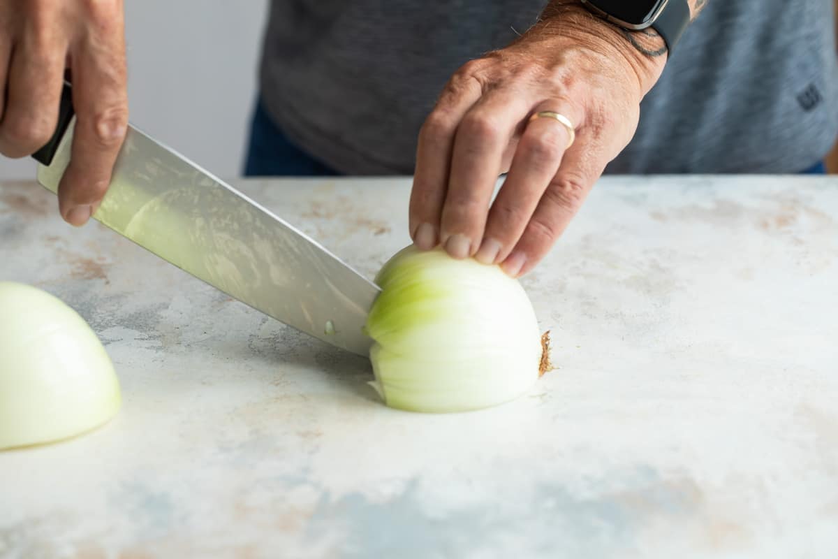Making straight cuts down an onion to dice.