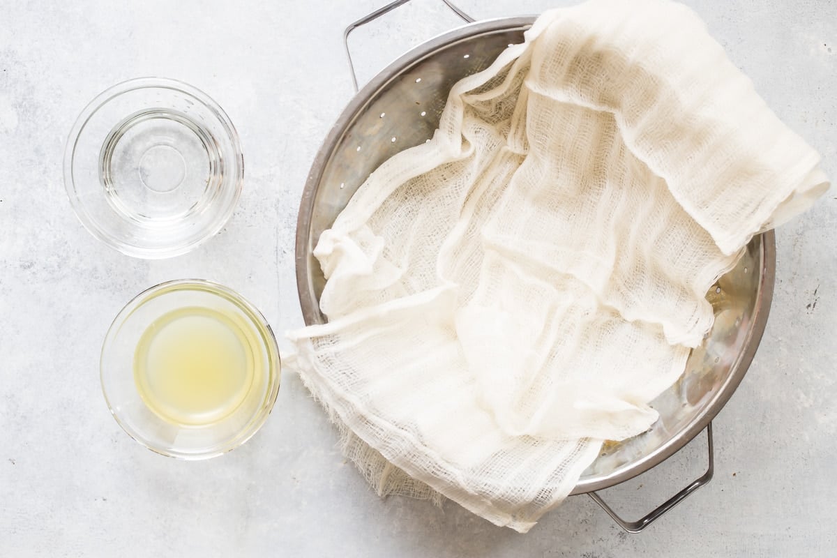 Ingredients and cooking tools needed to make ricotta cheese.