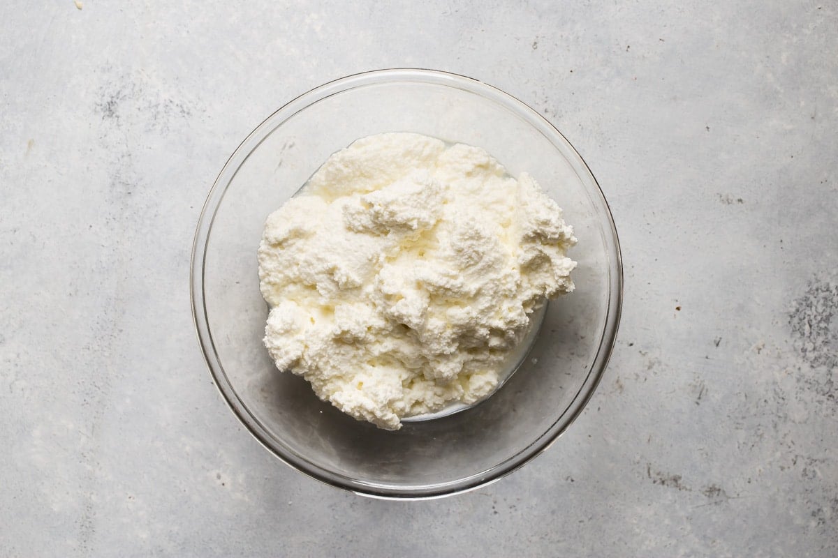 Ricotta cheese in a clear bowl.