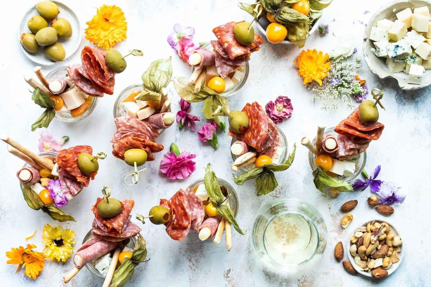 Eight jarcuteries on a table surrounded by various garnishes.
