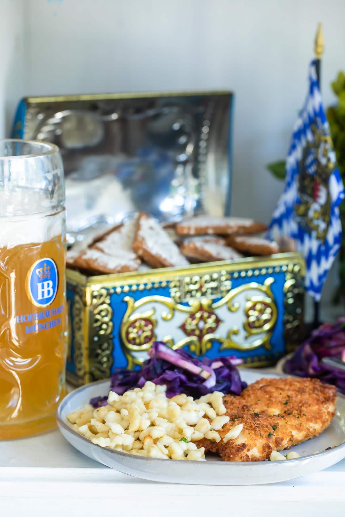 A table of Oktoberfest food including schnitzel, spaetzle, soft pretzels, German potato salad, Lebkuchen, and beer.