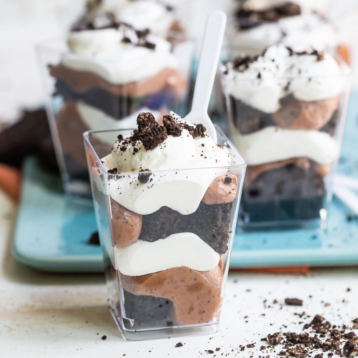 Miniature Oreo brownie trifles in small clear plastic cups.