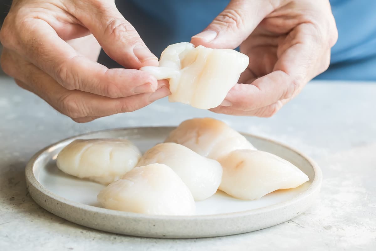 Removing the beard from a scallop.
