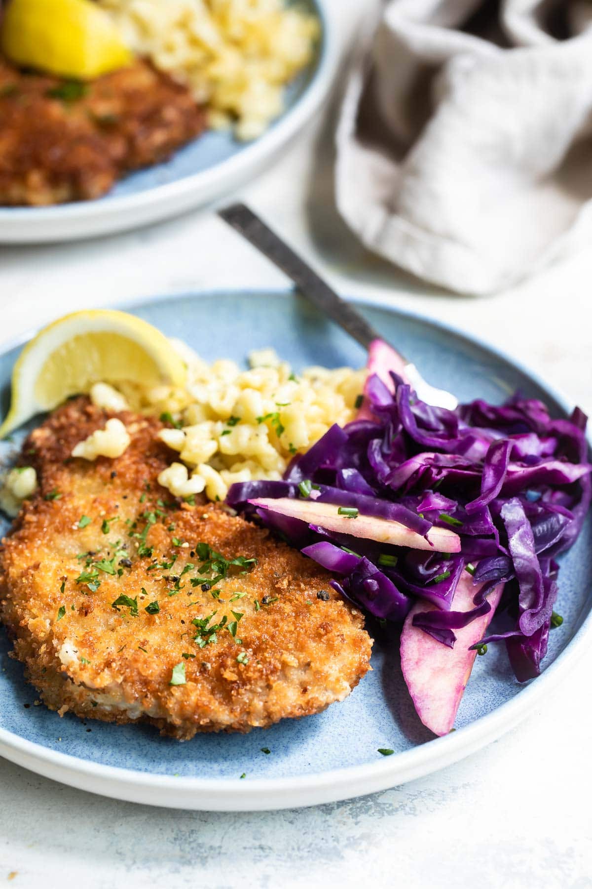 Plates of pork schnitzel, braised red cabbage, and spaetzle.