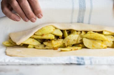 Strudel dough wrapped around an apple filling for Apple Strudel.