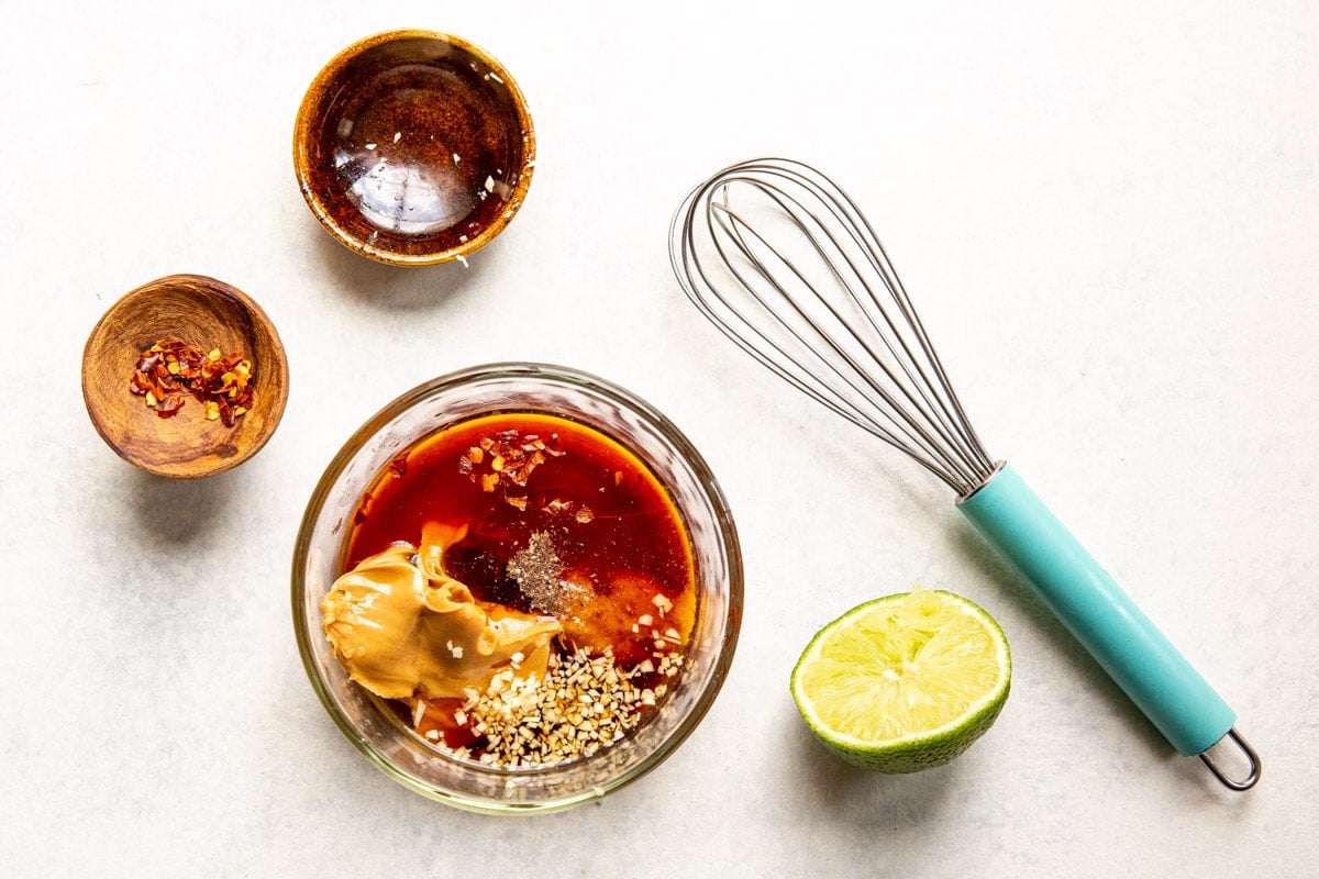 A bowl with ingredients for Thai peanut dressing.