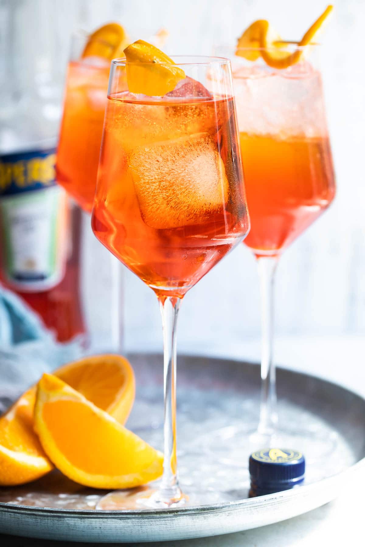 3 Aperol Spritz cocktails ona. metal tray.