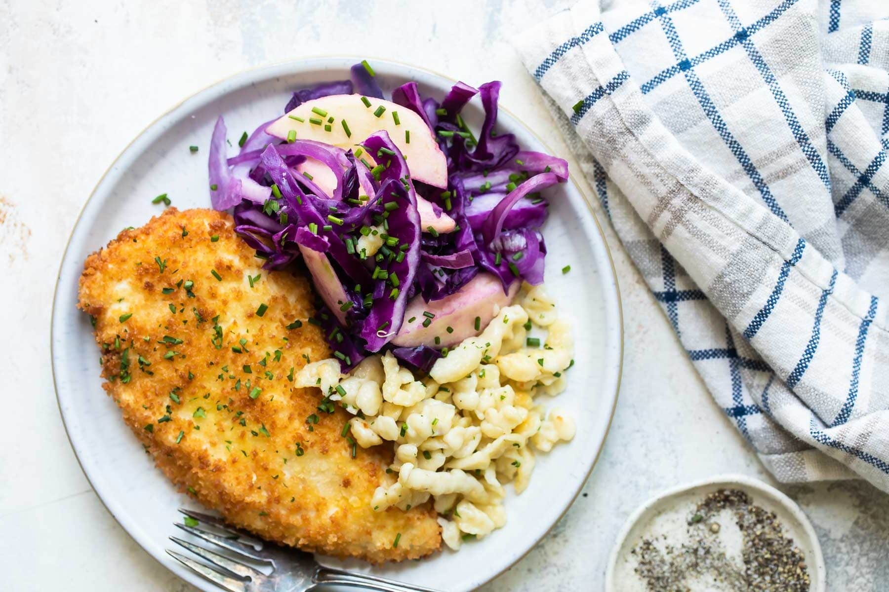 A plate of schnitzel, spaetzle, and braised red cabbage.