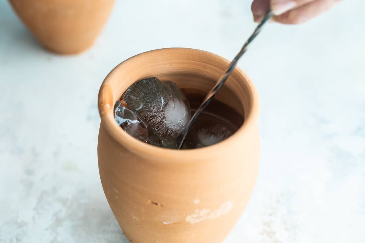 Making a cantarito cocktail in a clay cup.